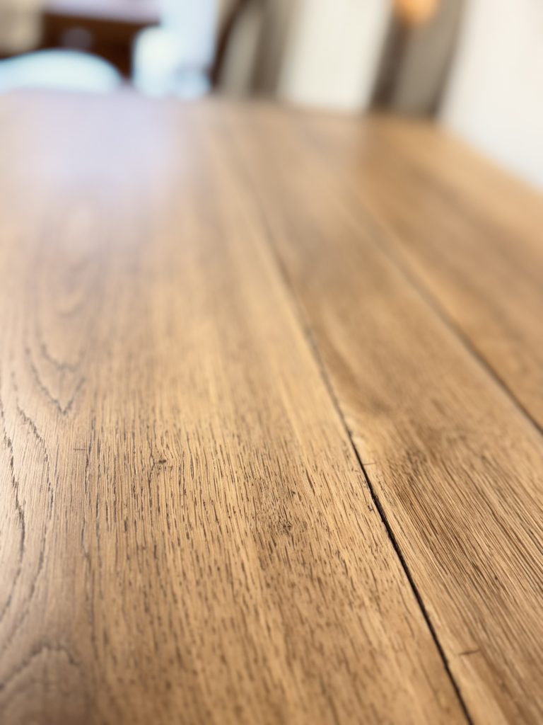 Gros plan sur le plateau en chêne du banc coffre avec finition vernis mat.